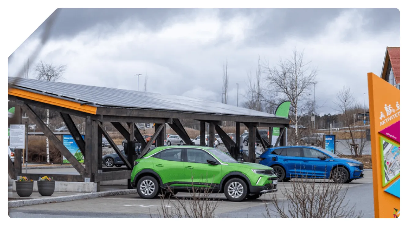 Elbiler parkert under et solcelletekket ladetak på parkeringsplassen ved Inspiria Science Center