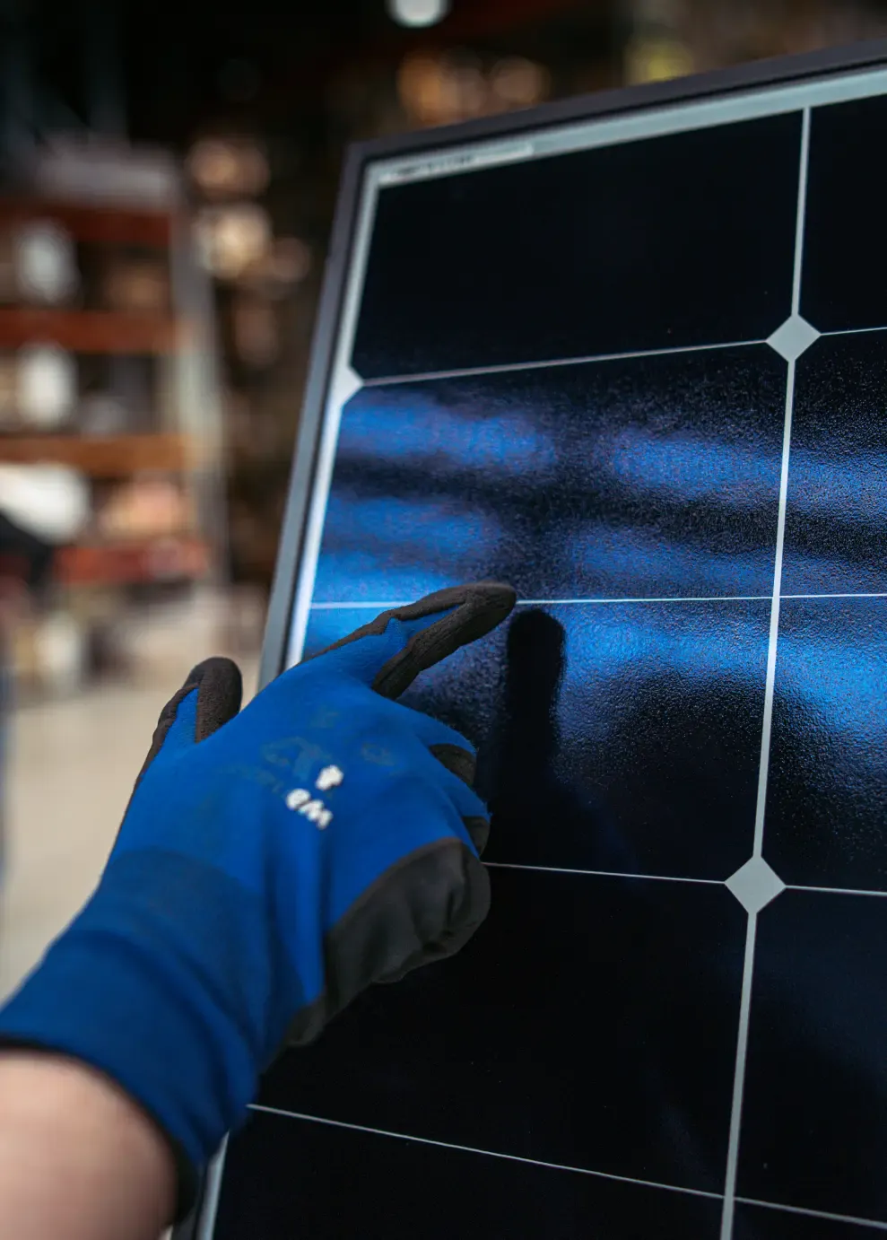 A hand resting on the surface of a solar panel