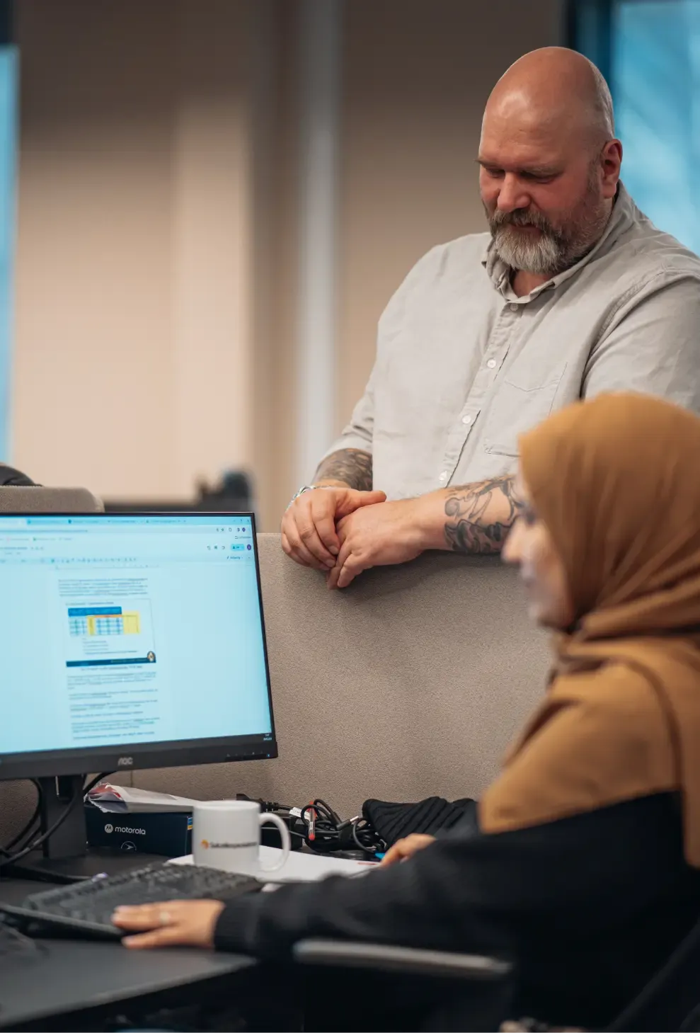 Two Solcellespesialisten colleagues talking at a desk in the office