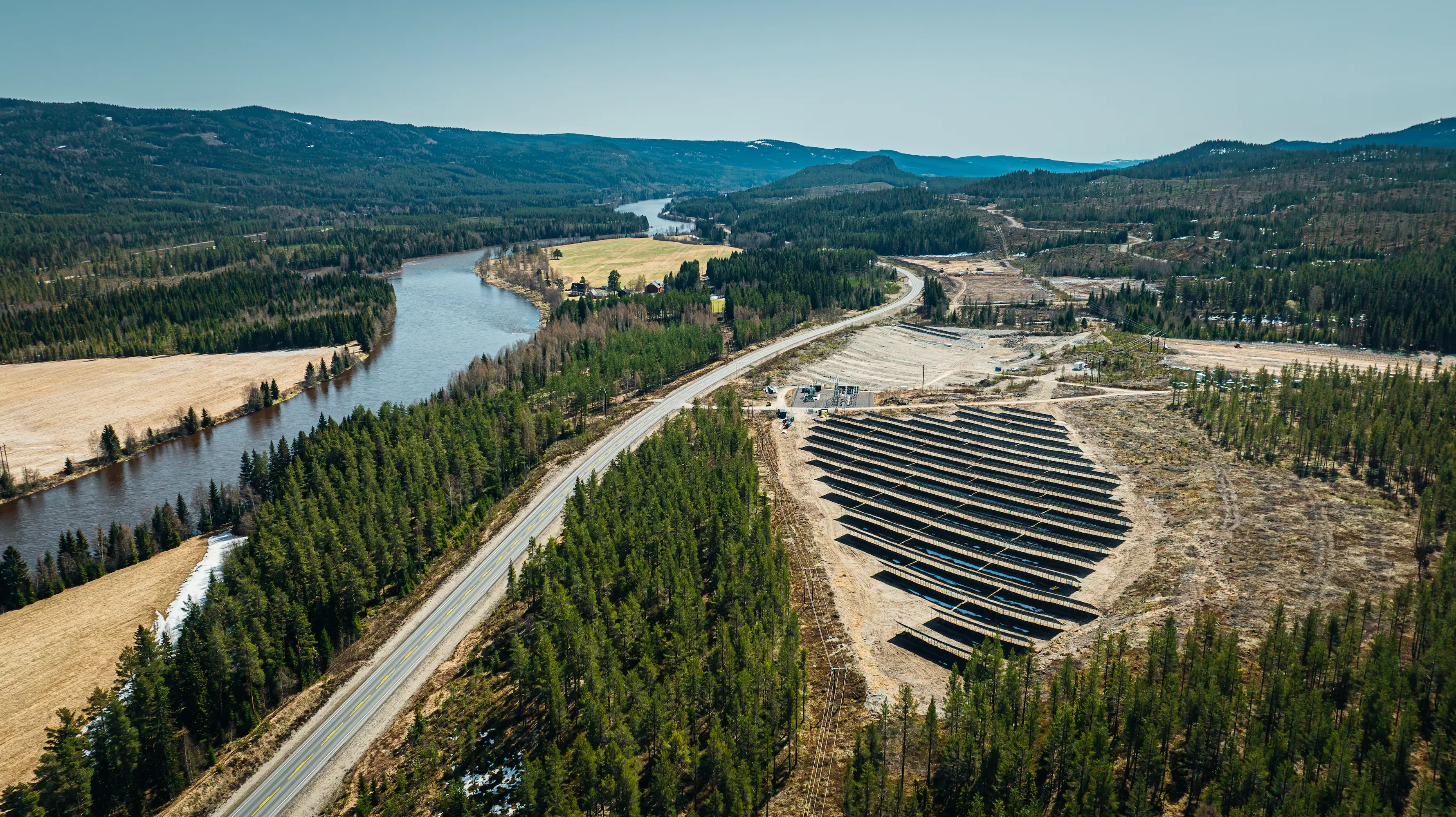 Bakkemontert solpark på et ryddet område ved en elv