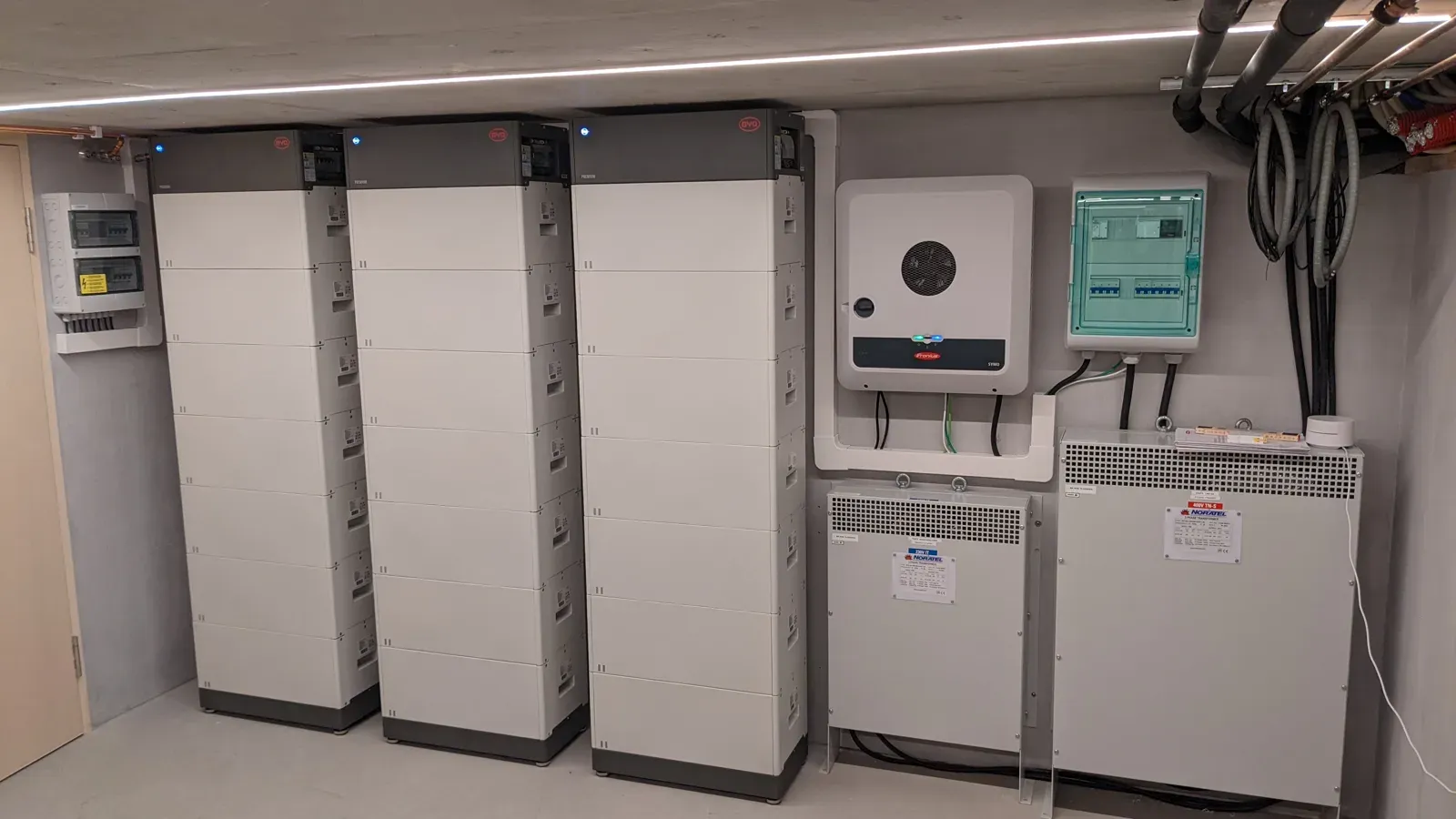 Tre batteristabler, en hybridvekselretter og to skilletransformatorer i et teknisk rom